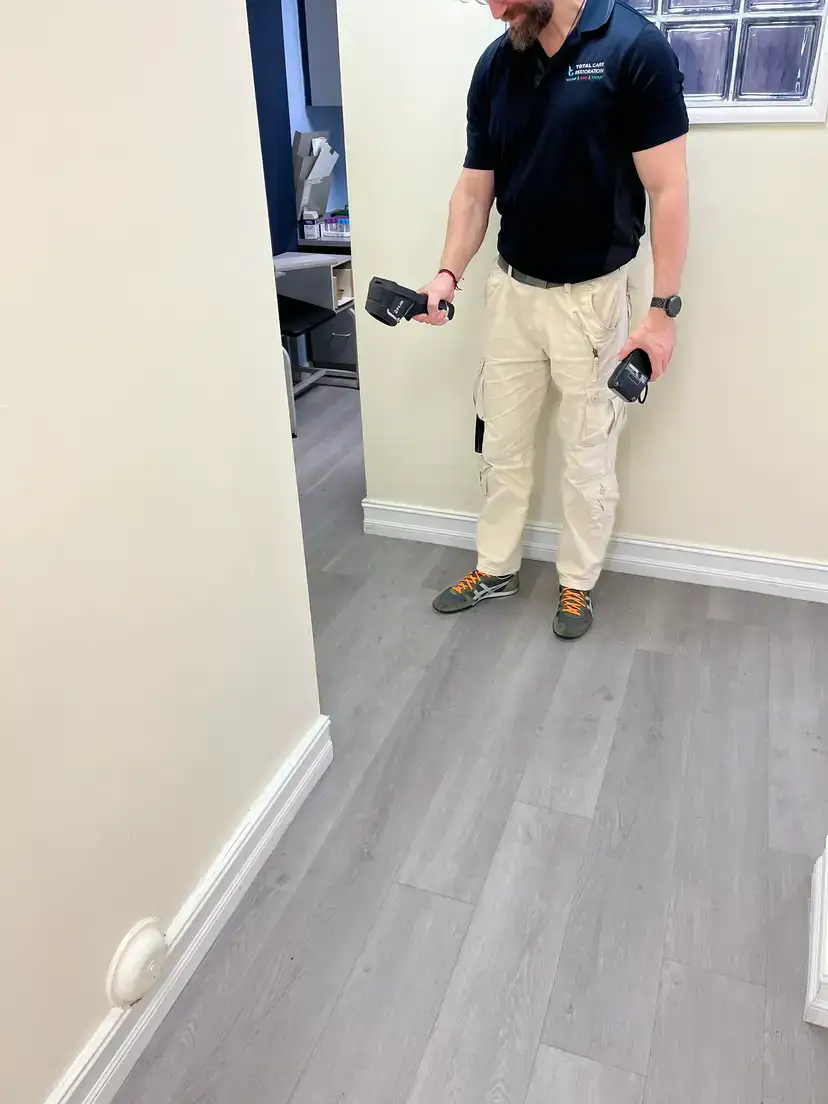 Leak detection technician inspecting a home's plumbing area during a diagnostic visit
