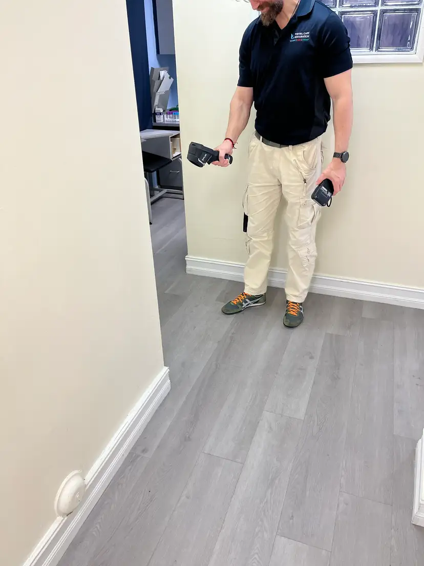 Leak detection technician inspecting a home's plumbing area during a diagnostic visit