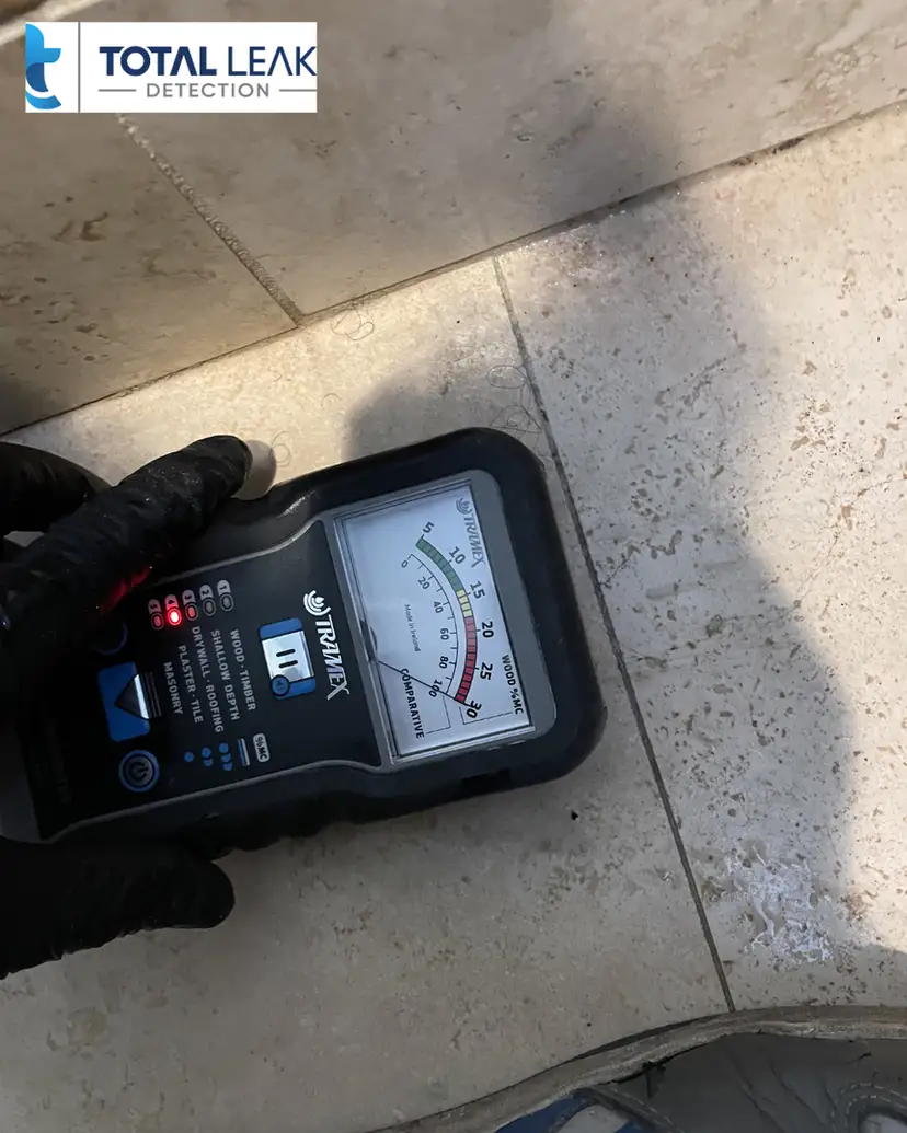 Close-up of a moisture meter being used during a leak investigation