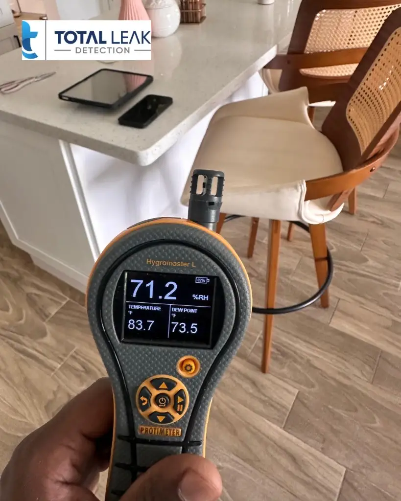 Protimeter hygrometer measuring indoor air humidity during mold testing in a Doral kitchen