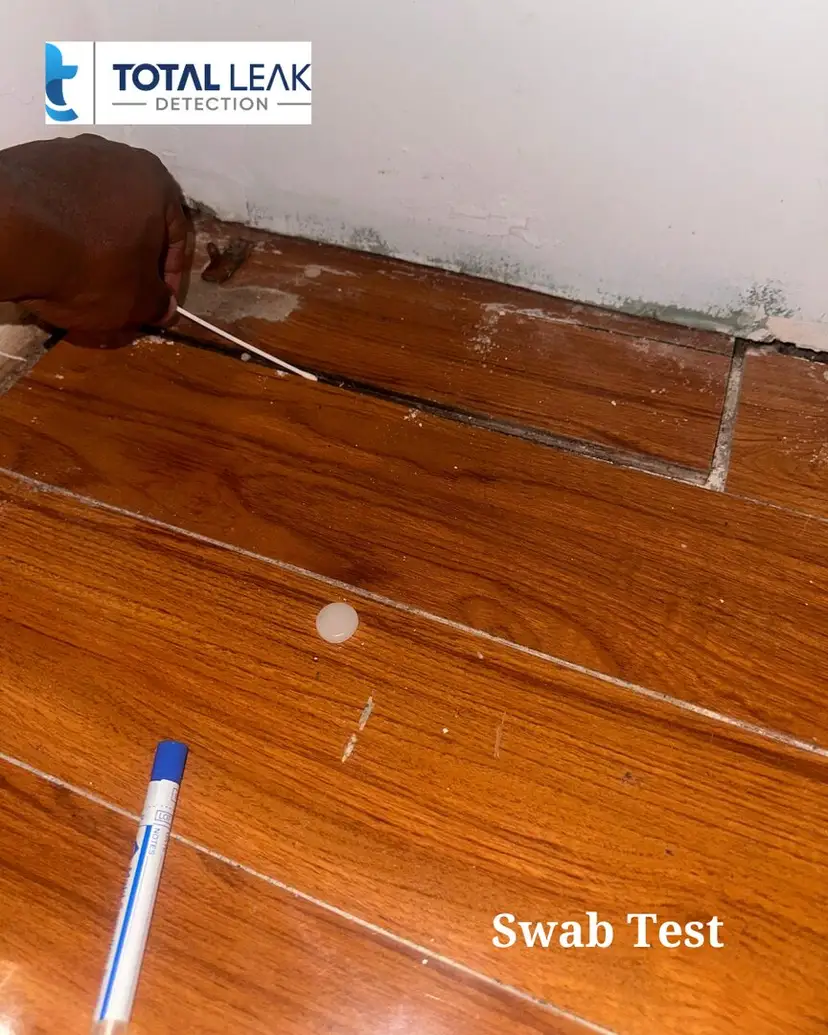 Swab test on a tile grout line during leak detection.