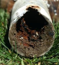 Clogged drain causing toilet bubbling when washing machine drains due to debris buildup in pipes